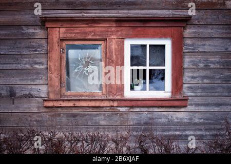 The  old one vs new one.Two old windows in the wall of ancient Latvian wooden house. Stock Photo