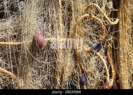 Orange fishing net with red and black floats, hanging on the sea front at Loutro, Crete, Greece Stock Photo