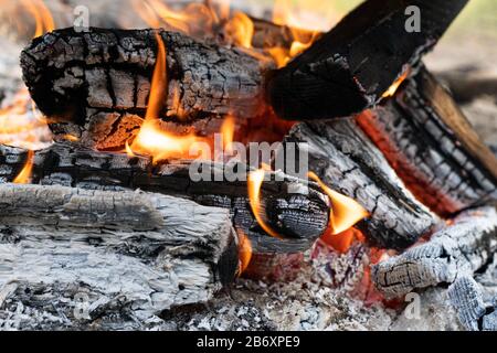 Photo of hot sparking live-coals burning. Orange flame of fire. Stock Photo