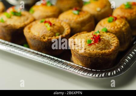 Traditional  English pork pies with cranberry sauce on a silver tray, English food Stock Photo
