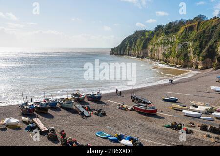 Beer, Devon, UK.  12th March 2020.  UK Weather.  View of the beach and fishing boats at the picturesque village of Beer in Devon on a day of warm spring sunshine and occasional showers.  Picture Credit: Graham Hunt/Alamy Live News Stock Photo