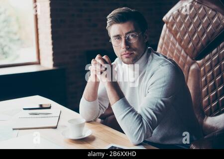 Portrait of nice skilled experienced attractive content shark partner company founder consultant sitting in chair at industrial loft brick style Stock Photo