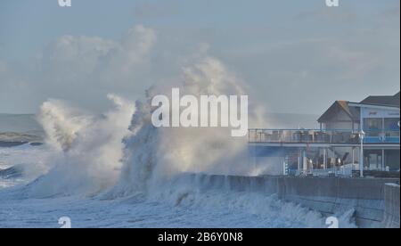 Large waves crash into the Beach Bar at Westward Ho! , Devon during an unusual high tide as tidal flooding hits the South Stock Photo