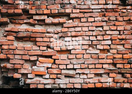 A crumbling red brick wall. Vintage background. Stock Photo