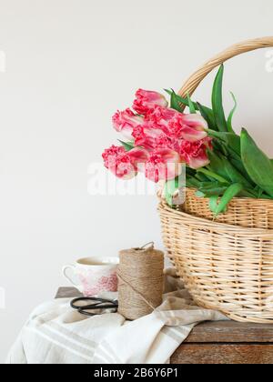 Spring composition with pink tulips in a basket Stock Photo