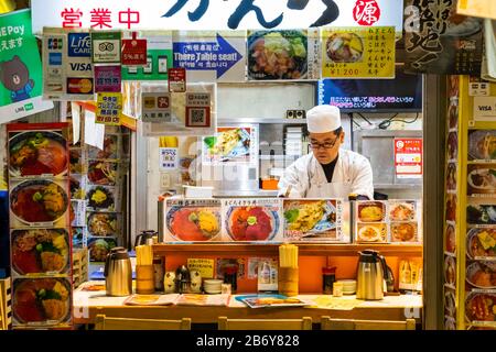 Japan, Honshu, Tokyo, Tsukiji, Tsukiji Outer Market, Seafood Restaurant with Chef at Counter Stock Photo