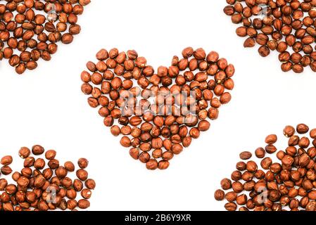 Heart shape made of hazelnuts on a white background. Brown walnut kernels with frame Stock Photo