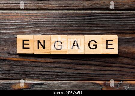 ENGAGE word written on wood block. ENGAGE text on wooden table for your desing, concept. Stock Photo