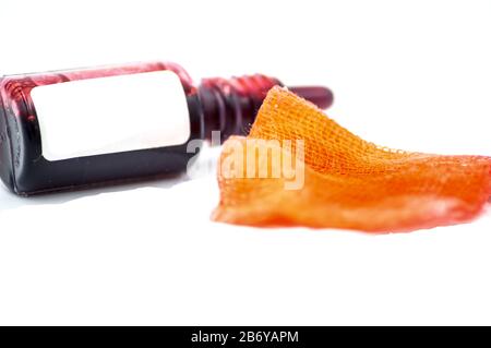 Studio macro of a pharmacy flask filled with a red liquid with a compress on a white background. Copy space. Stock Photo