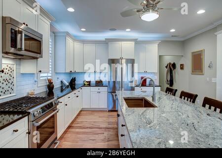 Beautiful luxury kitchen with quartz and granite countertops and white cabinets. Stock Photo