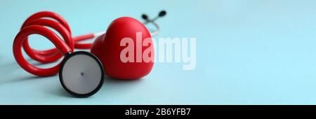Red stethoscope with heart on blue modern background