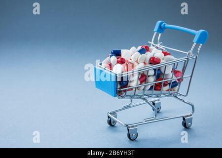 A concept image of a retail, shopping trolley or cart full of pills, tablets, antibiotics,painkillers creating resistance to viruses and bacteria Stock Photo