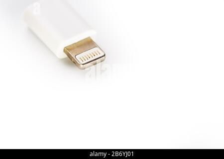 Connector lightning on a white background. This is a proprietary connector used to connect mobile devices to well-known host computers. Stock Photo