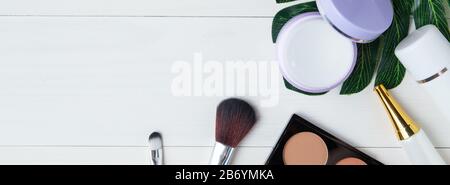 cosmetic makeup and skin care product and leaves on white wood table, beauty with treatment cream and moisturizer copy space on wooden desk, health an Stock Photo