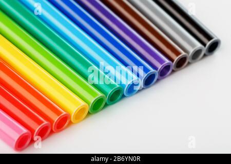 Multi-colored felt-tip pens, markers on a white isolated background. Rainbow colors overall plan, top view. Stock Photo