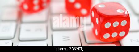 Red dices lying at white keyboard as online casino Stock Photo