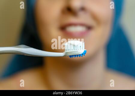 woman washing her teeth after shower daily routine . Stock Photo
