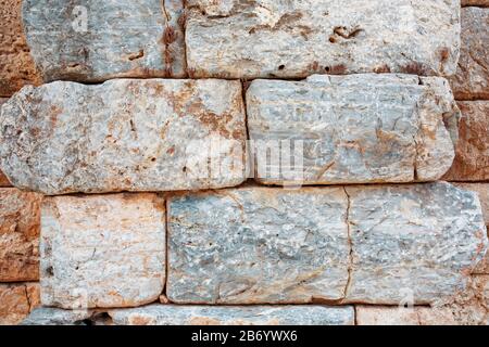 Texture of a stone wall made of large blocks. Elements of the building of ancient antiquity. Full screen texture Stock Photo