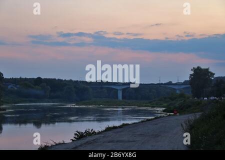 View of the wide Neman river over the bridge in the evening Stock Photo