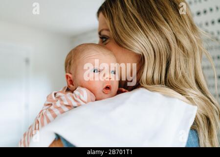Closeup portrait of a newborn baby girl being held by her mother Stock Photo