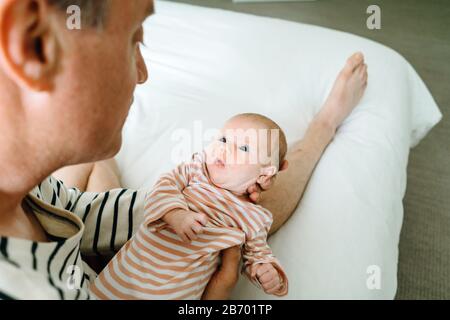 View from above of a newborn baby girl being held by her father Stock Photo