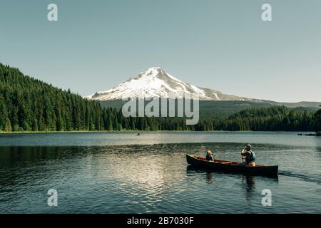 A father canoes with his daughter on Trillium Lake near Mt. Hood, OR. Stock Photo