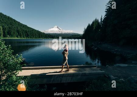 A father carries his daughter on his shoulders at Trillium Lake, OR. Stock Photo