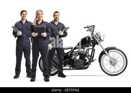 Full length portrait of a team of male and female workers in uniforms standung next to a motorcycle isolated on white background Stock Photo