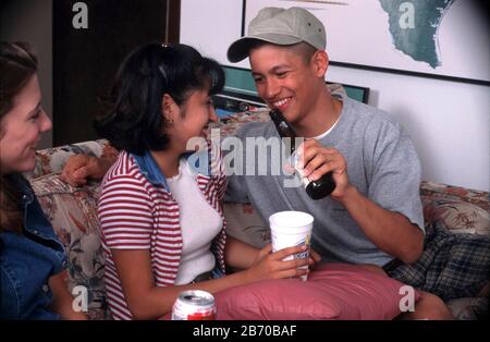Austin Texas USA, 1997: Under-age teens get drunk and giggly while drinking beer during house party. MR ©Bob Daemmrich Stock Photo