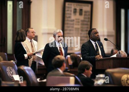 Austin, Texas USA, 1997: Texas State Rep. Glenn Lewis at microphone debates from back of House of Representatives. Representative Jim McReynolds (D) is at left. ©Bob Daemmrich Stock Photo