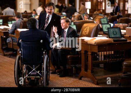 Austin Texas USA, 1997: Texas State Rep. Jim Pitts, center, talks over bills with colleagues from his desk on the floor of the House during the legislative session. ©Bob Daemmrich Stock Photo