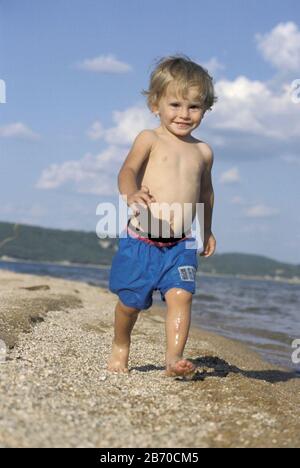 Lake Buchanan, Burnet County, Texas USA, 1997:  Twenty-two month old boy playing in the sand in summer. MR ©Bob Daemmrich Stock Photo