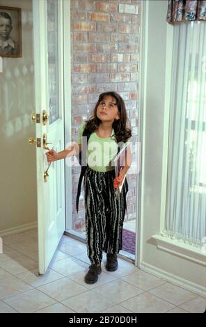 Austin Texas USA, 1997: Latchkey children: 8-year-old Anglo-Panamanian girl comes home from school to empty house while her parents are at work.  MR ©Bob Daemmrich Stock Photo