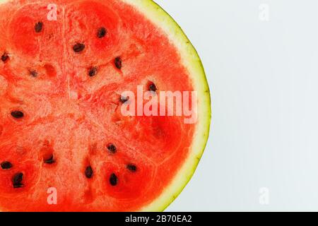 Half of juicy, red watermelon on a white background, texture of juicy pulp and mesmeses of ripe watermelon Stock Photo