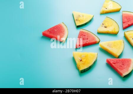 Slices of fresh pieces of yellow and red watermelon on a blue background. Free place. Stock Photo