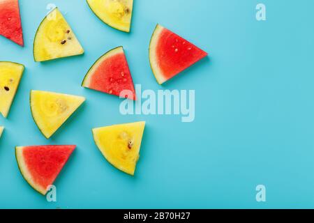Slices of fresh pieces of yellow and red watermelon on a blue background. Free place. Stock Photo