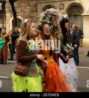 Rijeka, Croatia, February 23rd, 2020. Girls costumed in colorful costume of fairy tales walking down the street during the carnival and cheerful chatt Stock Photo