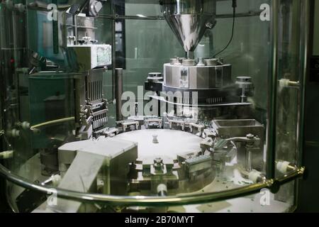 Machine making pills in a pharmaceutical factory Stock Photo