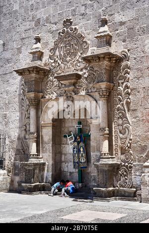 Boys playing in front of Baroque stonework on church in Arequipa, Peru. Stock Photo