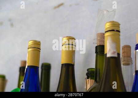 Empty wine bottles close-up. Group of various glass bottles. Alcoholism, unhealthy lifestyle. Side view. Shooting from the bottom up. Selective focus. Stock Photo