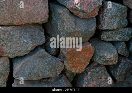 Granite stones stacked one on one. Large pieces of raw granite. Abstract background. Selective focus. Stock Photo