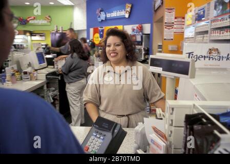 Austin, Texas USA, 2004:  ExxonMobil convenience store clerk (right) waiting on customer.  ©Bob Daemmrich Stock Photo