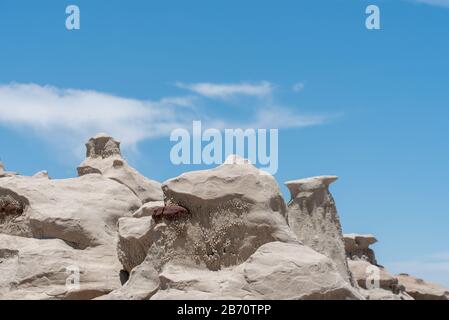 Low angle landscape of unusual grey rock formations against blue sky in Bisti Badlands in New Mexico Stock Photo