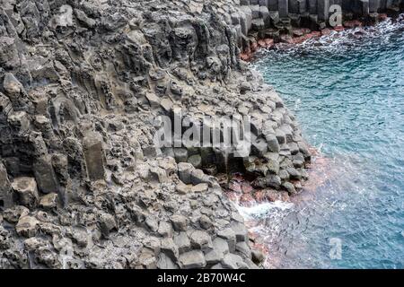 Basaltic Volcanic Columnar Joints Coast and Blue Water in JungMun in Jeju Island, South Korea. Stock Photo