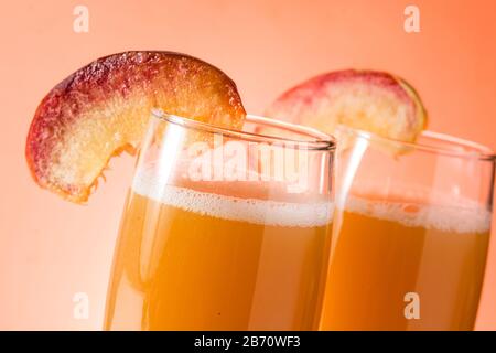 Bellini champagne cocktail in crystal glass on orange background. Close up Stock Photo
