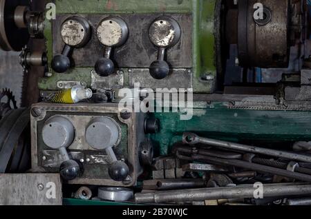 Local perspective on old machine equipment. Fragment of an old lathe. Handles for manual control of speed and direction of rotation of the spindle. In Stock Photo