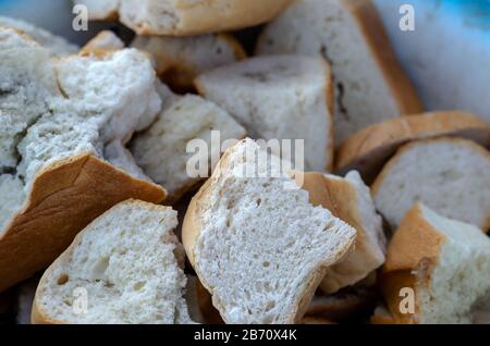 Dry slices of wheat bread with mold. Large pieces of spoiled bread. Close-up. Selective focus. Side view. Eye level shooting. Stock Photo
