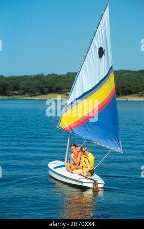 Lake Travis, Texas USA: Two teen  girls sailing a Sunfish boat during Girl Scout summer camp session.  ©Bob Daemmrich Stock Photo