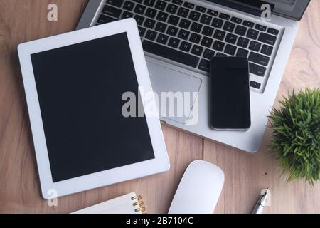 top view of digital tablet , laptop, smart phone and notepad on orange background  Stock Photo