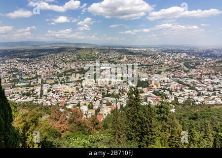 Cityscape of Tbilisi, Georgia as viewed from Mtatsminda View Point. The Holy Trinity Cathedral of Tbilisi is a prominent landmark. Stock Photo